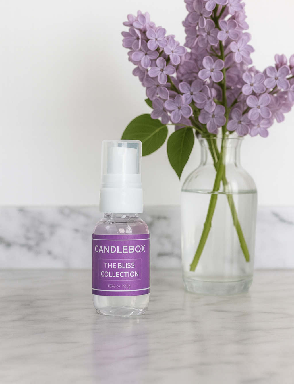 BLISS Hand Sanitizer bottle with purple label next to a vase of purple flowers on a marble surface