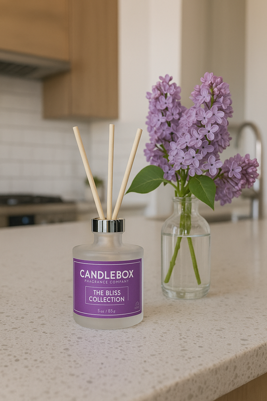 BLISS Diffuser reed diffuser on kitchen countertop next to purple lilac flowers in glass vase