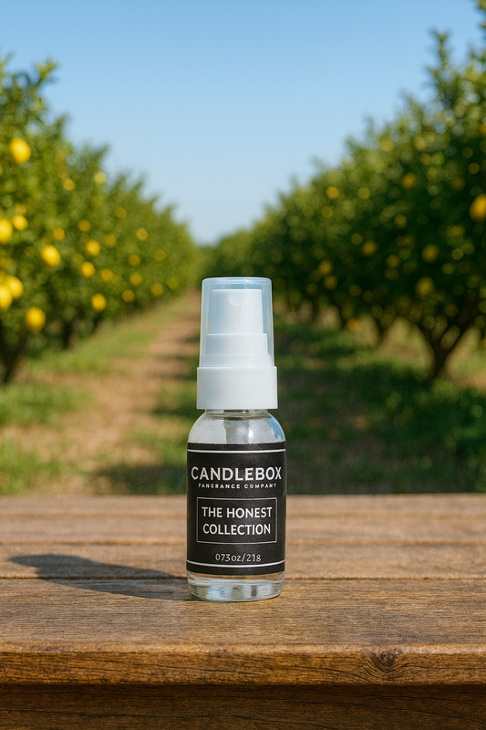Small clear bottle of HONEST Hand Sanitizer from Candlebox on wooden surface outdoors with blurred orchard background