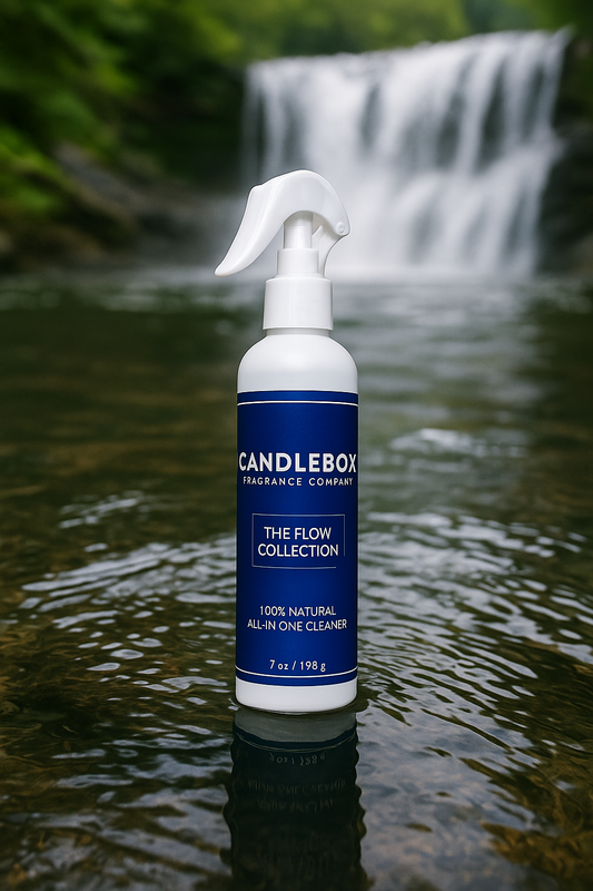 Flow All-in-One Cleaner spray bottle from Candlebox Fragrance Company in natural water setting with waterfall background