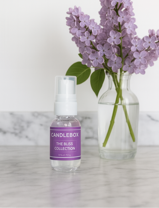 BLISS Hand Sanitizer bottle with purple label next to a vase of purple flowers on a marble surface